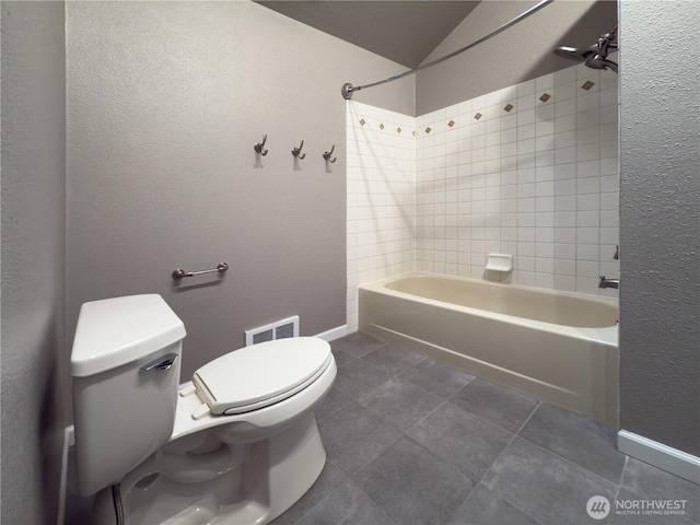 bathroom featuring visible vents, baseboards, toilet, tile patterned floors, and shower / bath combination