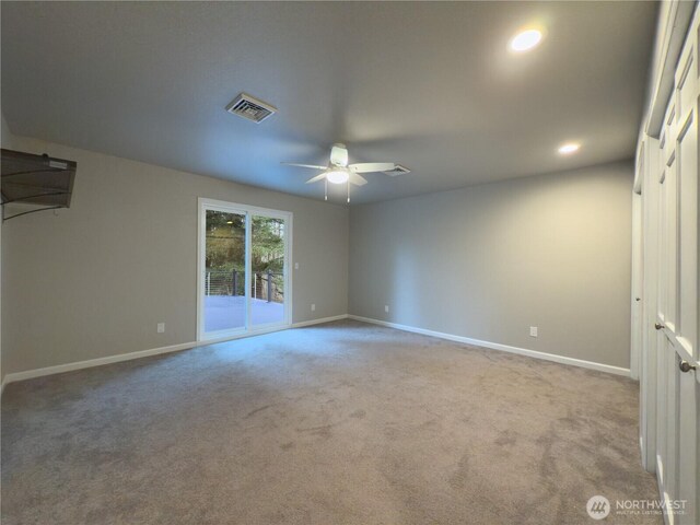 carpeted spare room featuring baseboards, visible vents, and a ceiling fan