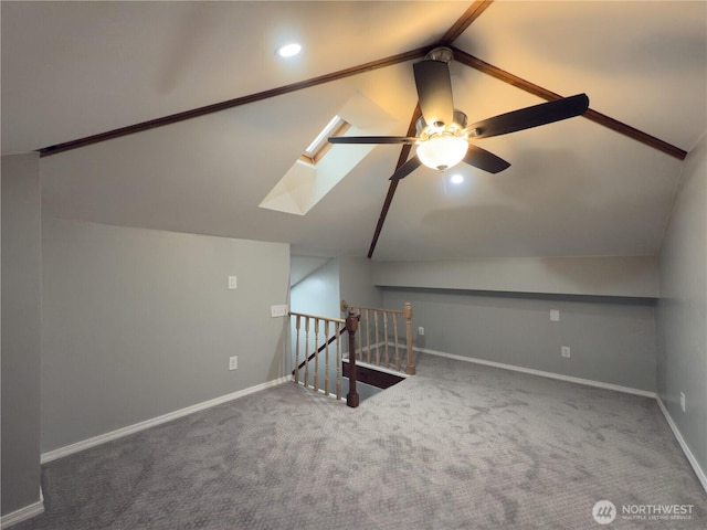 bonus room with carpet flooring, baseboards, vaulted ceiling with skylight, recessed lighting, and a ceiling fan