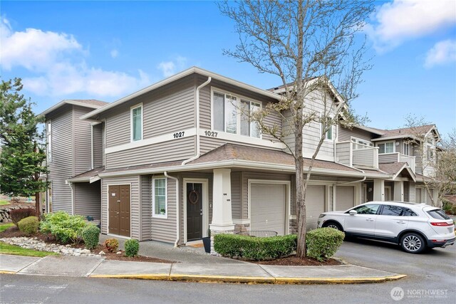 multi unit property with driveway, a balcony, and an attached garage