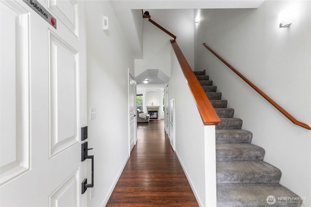interior space featuring stairway, a high ceiling, and dark wood-style flooring