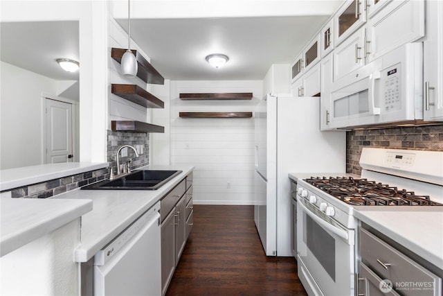 kitchen featuring open shelves, decorative backsplash, white appliances, dark wood-style floors, and a sink