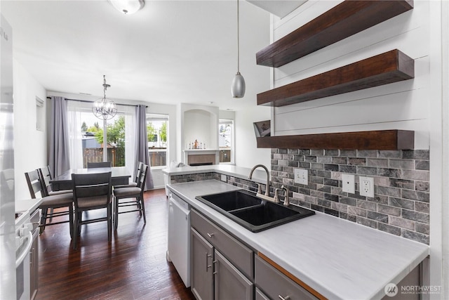 kitchen with open shelves, decorative backsplash, dark wood-type flooring, a sink, and dishwasher