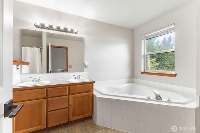 full bathroom featuring double vanity, a sink, and a garden tub