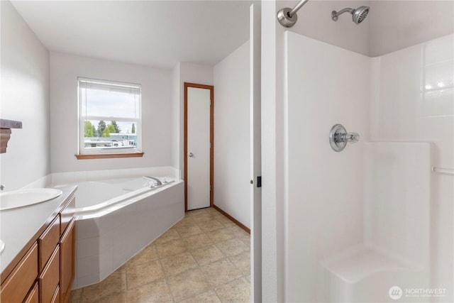 bathroom with walk in shower, a garden tub, and vanity
