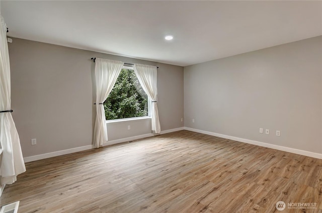 unfurnished room featuring visible vents, baseboards, and light wood-style flooring