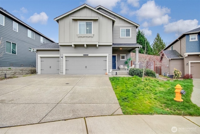 craftsman house featuring a front yard, board and batten siding, concrete driveway, and an attached garage