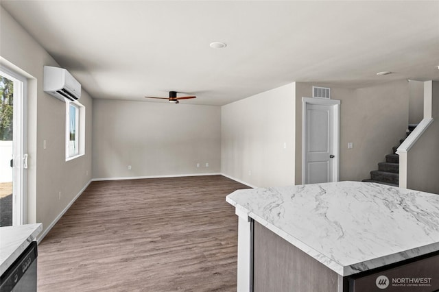 425 Pear Dr, Tieton, WA 98947 - kitchen with visible vents, an AC wall unit, wood finished floors, a ceiling fan, and stainless steel dishwasher
