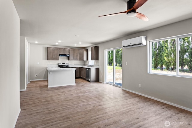425 Pear Dr, Tieton, WA 98947 - kitchen with light wood-style flooring, exhaust hood, electric range, an AC wall unit, and dark brown cabinets