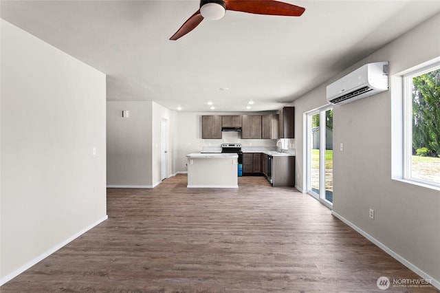 425 Pear Dr, Tieton, WA 98947 - kitchen with a wall mounted AC, light countertops, ceiling fan, stainless steel range with electric cooktop, and dark brown cabinetry