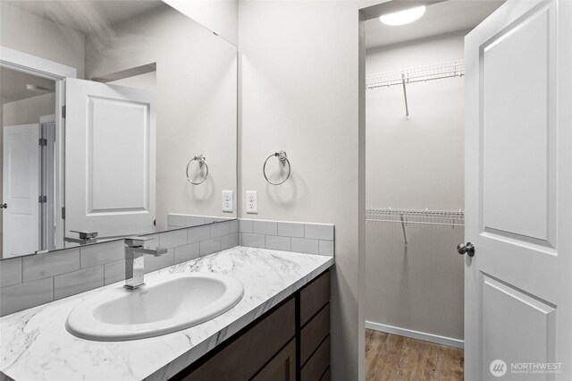 425 Pear Dr, Tieton, WA 98947 - bathroom featuring a walk in closet, tasteful backsplash, wood finished floors, and vanity
