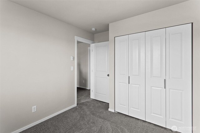 425 Pear Dr, Tieton, WA 98947 - unfurnished bedroom with a closet, baseboards, and dark colored carpet