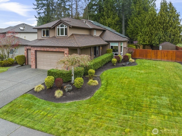 view of front of property featuring a front lawn, driveway, fence, an attached garage, and a shingled roof