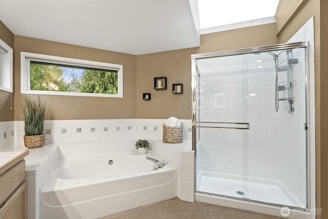 full bathroom featuring a garden tub, vanity, and a stall shower