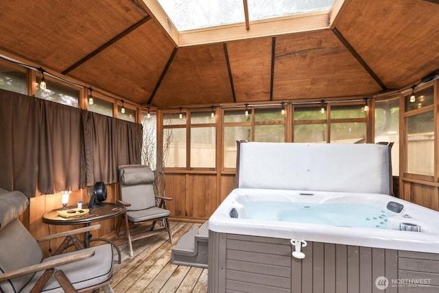 sunroom featuring a hot tub and a skylight