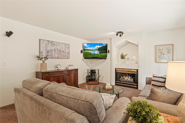 living area featuring a glass covered fireplace and carpet flooring