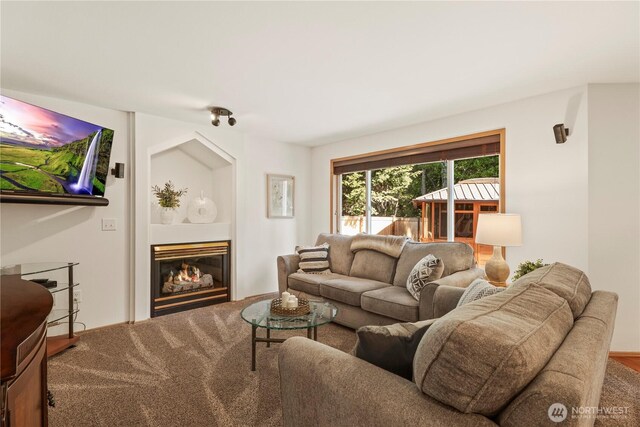 carpeted living room with a glass covered fireplace