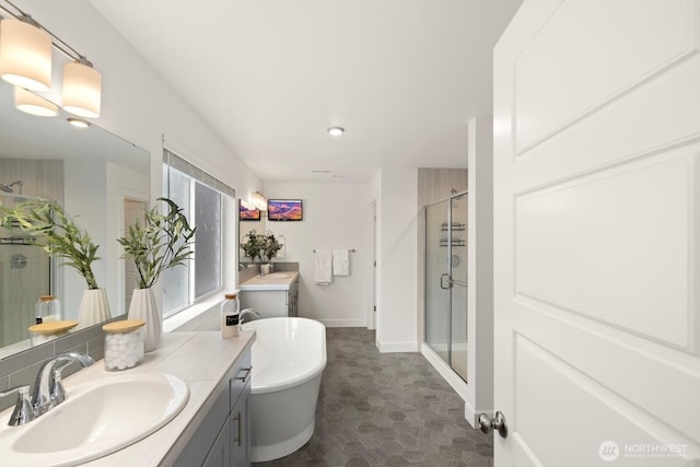 full bathroom with baseboards, a stall shower, vanity, and a freestanding bath