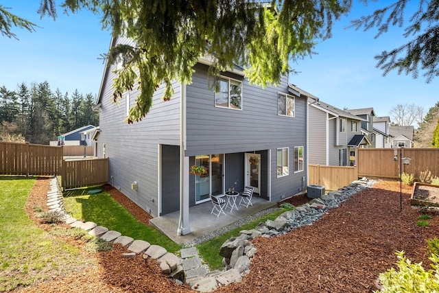 back of property featuring a lawn, a fenced backyard, and a patio area