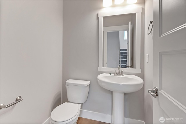 17318 74th Avenue Ct E, Puyallup, WA 98375 - half bathroom featuring toilet, baseboards, and a sink