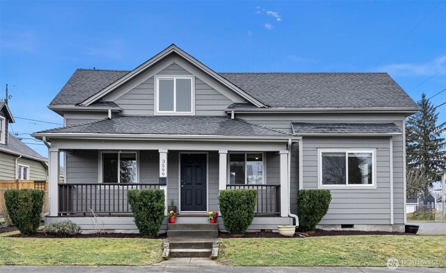 bungalow featuring covered porch, a front lawn, crawl space, and roof with shingles