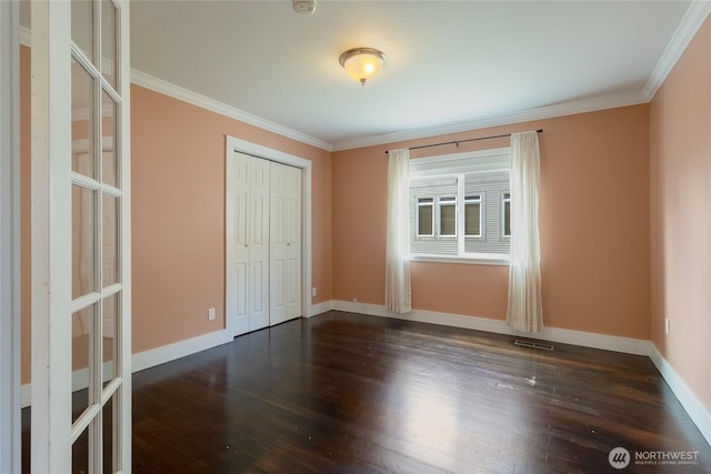 816 Washington St, Walla Walla, WA 99362 - unfurnished bedroom featuring visible vents, ornamental molding, dark wood-type flooring, and a closet