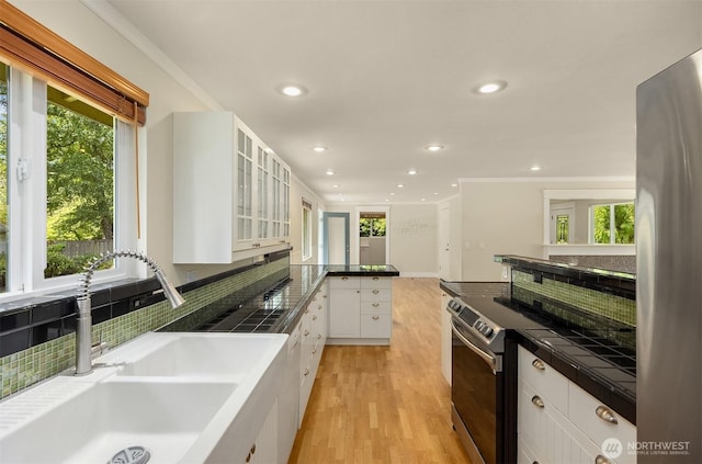 737 Park Ave NE, Bainbridge Island, WA 98110 - kitchen with a sink, stainless steel appliances, white cabinets, healthy amount of natural light, and recessed lighting