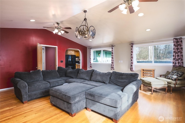 living area featuring arched walkways, ceiling fan with notable chandelier, recessed lighting, vaulted ceiling, and wood finished floors