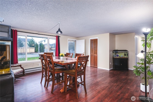 dining space featuring baseboards, wood finished floors, and a textured ceiling