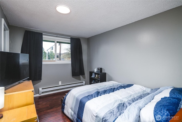 bedroom featuring a textured ceiling, wood finished floors, and baseboard heating