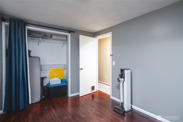 bedroom featuring visible vents, hardwood / wood-style flooring, baseboards, and a textured ceiling
