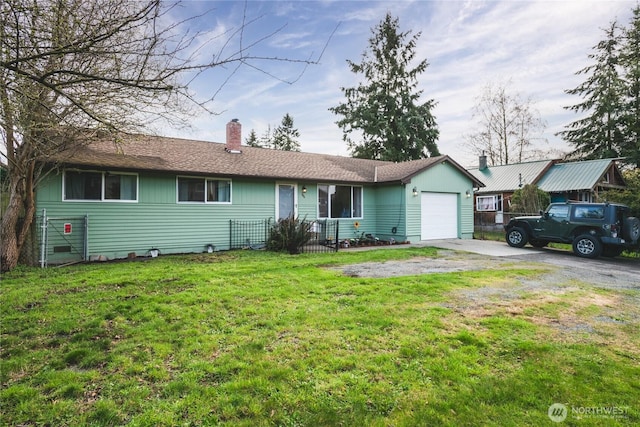 ranch-style home featuring a chimney, a garage, a front yard, and aphalt driveway