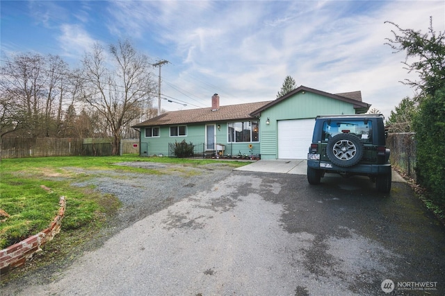 single story home with a garage, fence, a front lawn, a chimney, and driveway