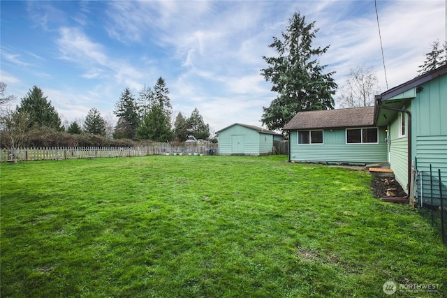 view of yard featuring a storage shed, an outbuilding, and fence