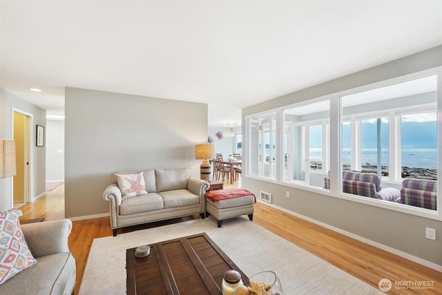 858 Livingston Bay Shore Dr, Camano Island, WA 98282 - living area featuring a water view, baseboards, light wood-style floors, and visible vents