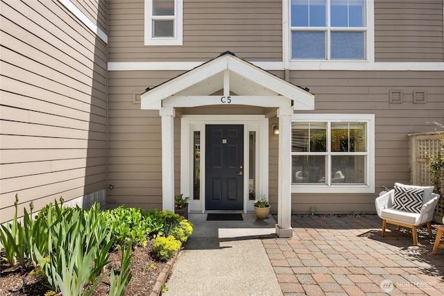 view of exterior entry with a patio area