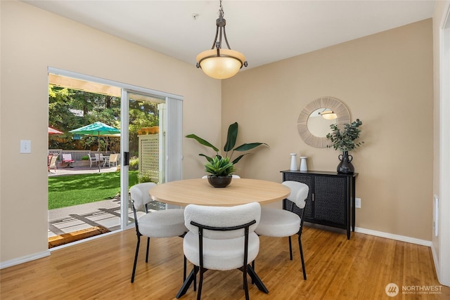 dining room with baseboards and light wood-type flooring