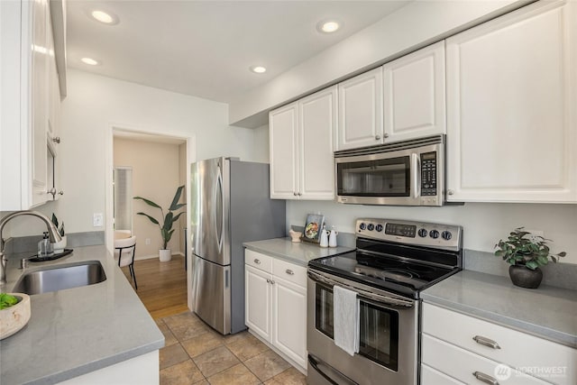 kitchen featuring recessed lighting, a sink, white cabinetry, and appliances with stainless steel finishes