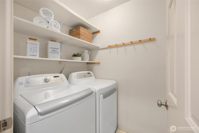 clothes washing area featuring separate washer and dryer and laundry area