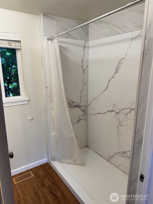 604 27th Ave SE, Puyallup, WA 98374 - full bath with a shower with shower curtain, visible vents, baseboards, and wood finished floors