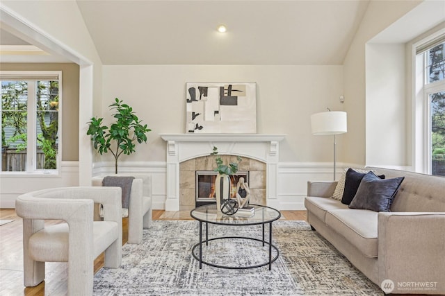 2070 277th Ave SE, Sammamish, WA 98075 - living room with wainscoting, wood finished floors, lofted ceiling, and a tiled fireplace