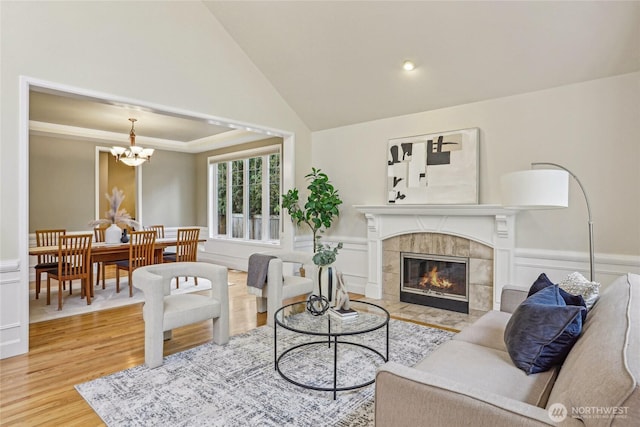 2070 277th Ave SE, Sammamish, WA 98075 - living room with wood finished floors, a chandelier, a tile fireplace, wainscoting, and lofted ceiling