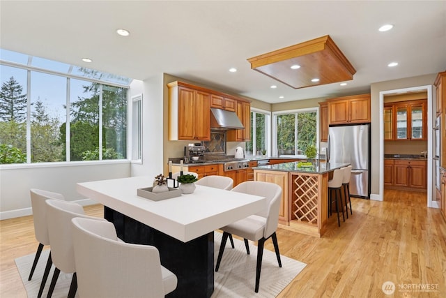 2070 277th Ave SE, Sammamish, WA 98075 - kitchen with stainless steel appliances, under cabinet range hood, a kitchen island, light wood finished floors, and recessed lighting