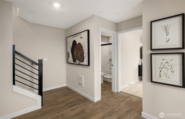 corridor featuring stairway, visible vents, baseboards, and wood finished floors