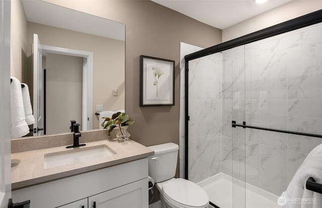 full bath featuring toilet, a stall shower, and vanity