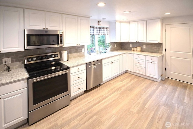 21901 N Clearlake Blvd SE, Yelm, WA 98597 - kitchen with appliances with stainless steel finishes, white cabinets, light wood finished floors, a sink, and recessed lighting