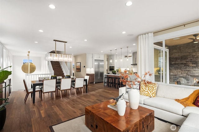 living area with recessed lighting, stairway, and dark wood finished floors