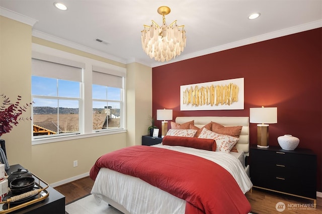 bedroom featuring an inviting chandelier, wood finished floors, visible vents, and ornamental molding