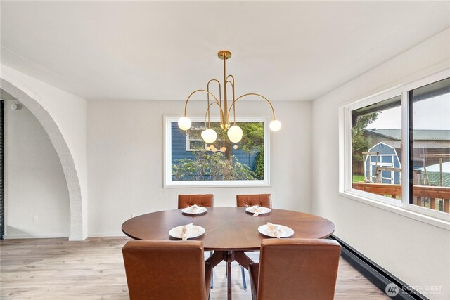 1309 W 5th St, Aberdeen, WA 98520 - dining area featuring arched walkways, baseboards, and light wood-style floors