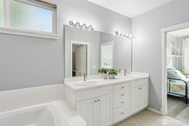 bathroom featuring a sink, ensuite bathroom, tile patterned floors, and double vanity